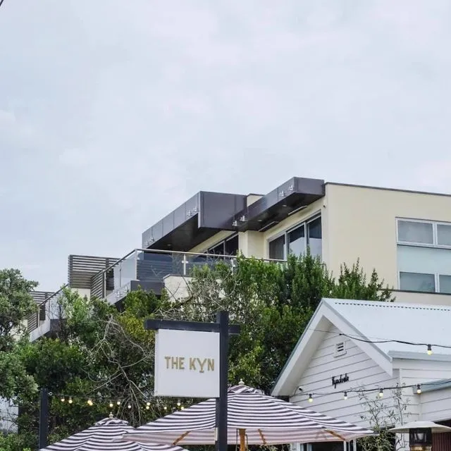 Modern building "The Kyn" featuring striped awnings.