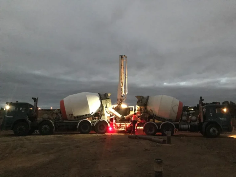 Cement trucks working at dawn, construction site.