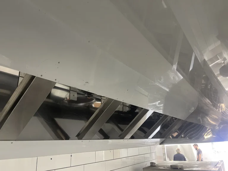 Commercial kitchen with stainless steel ventilation system.