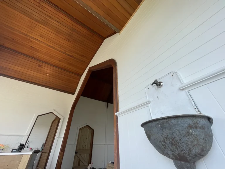 Wooden ceiling and white walls with vintage washbasin.