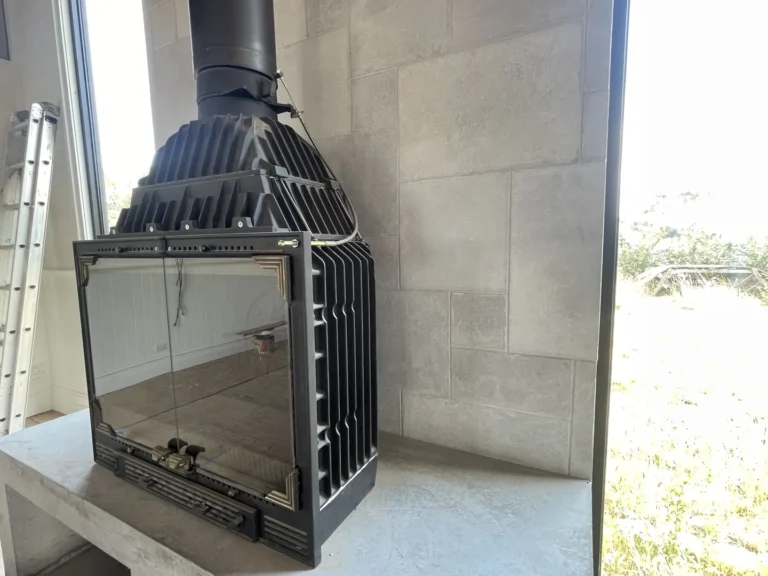 Modern fireplace in bright, unfinished outdoor space.